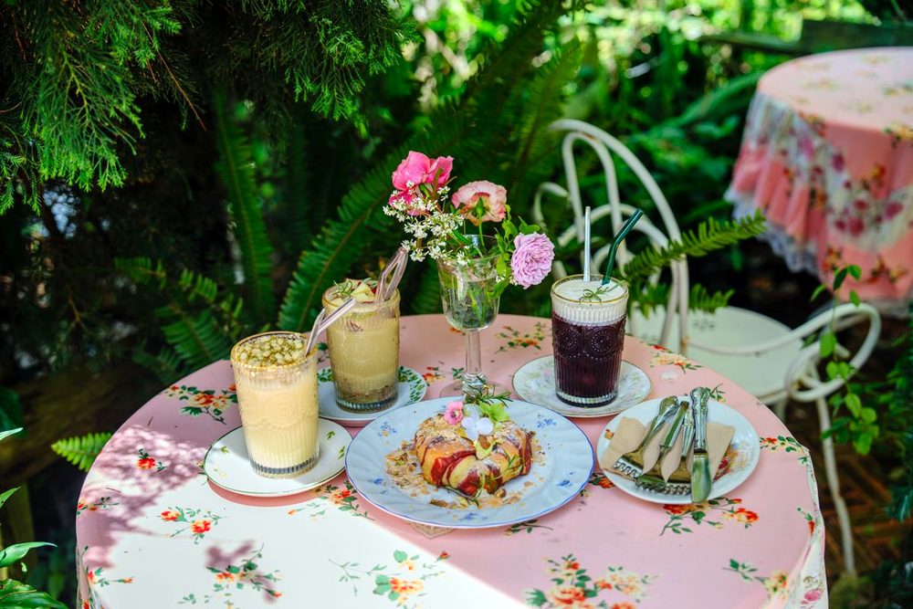 Cold drinks and a plate on a flowered garden table